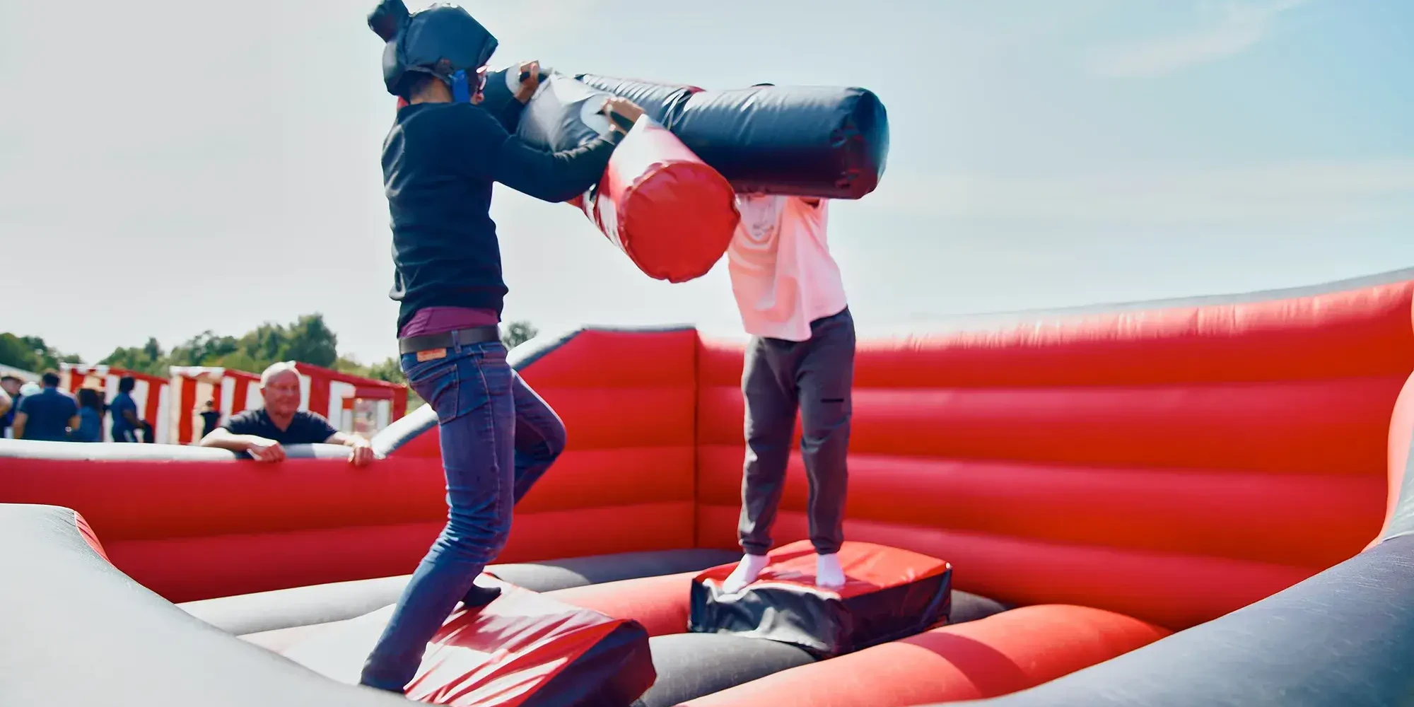 opponents fighting in inflatable team building activity with pugil sticks