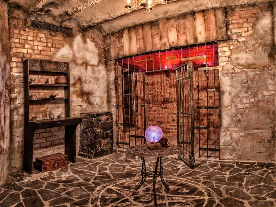 Digital recreation of a virtual escape room with prison doors and a purple glowing globe