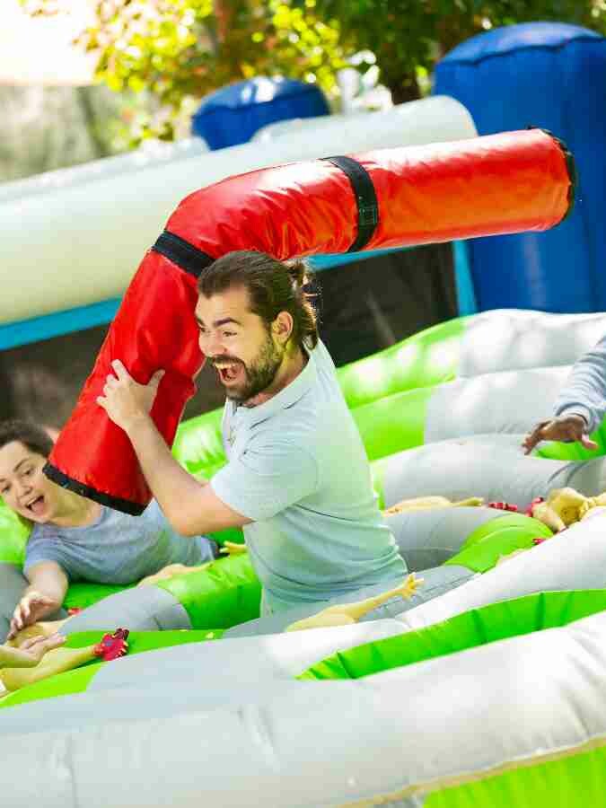 People laughing in inflatable team building event held outdoors in the summer