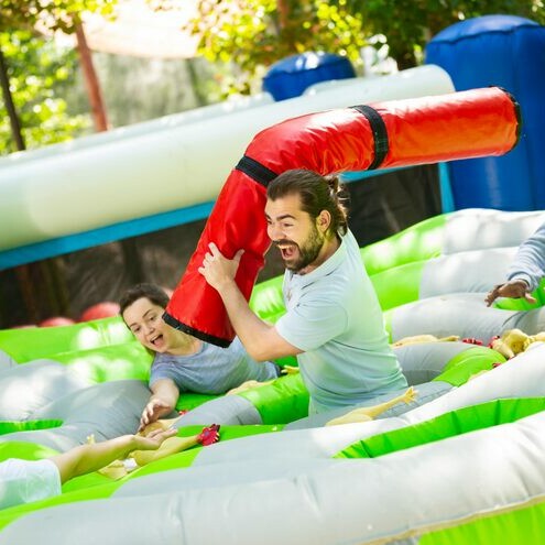 Man with a large foam baton on a foam filled inflatable