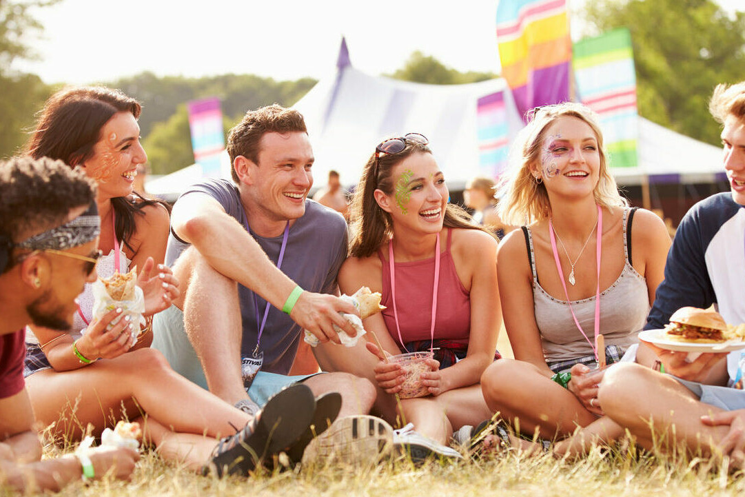 Group of 5 people sitting and laughing at a company away day festival