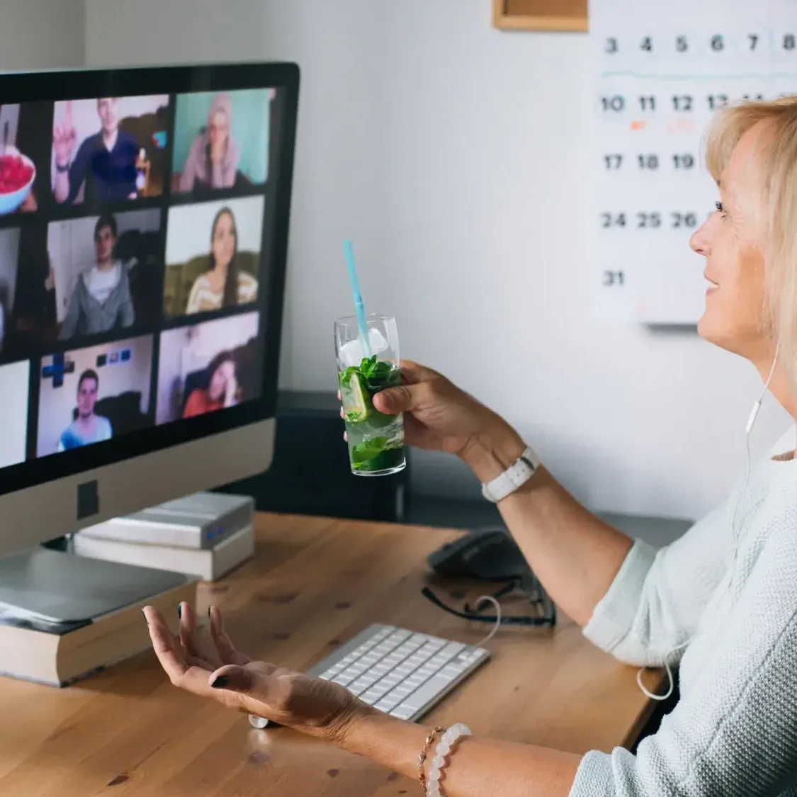 Woman holding mojito during cocktail making virtual team building event