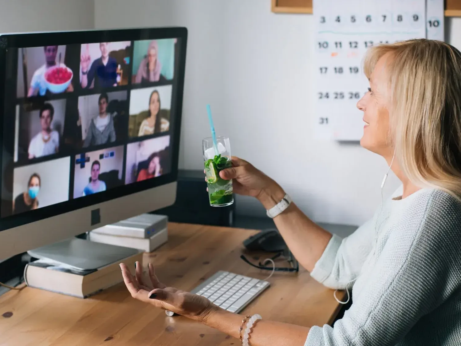 Woman holding mojito during cocktail making virtual team building event