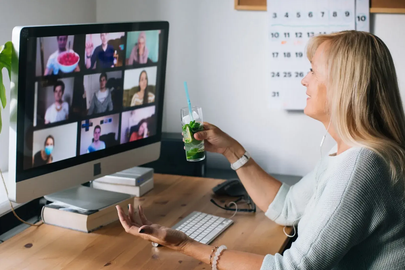 Woman holding mojito during cocktail making virtual team building event