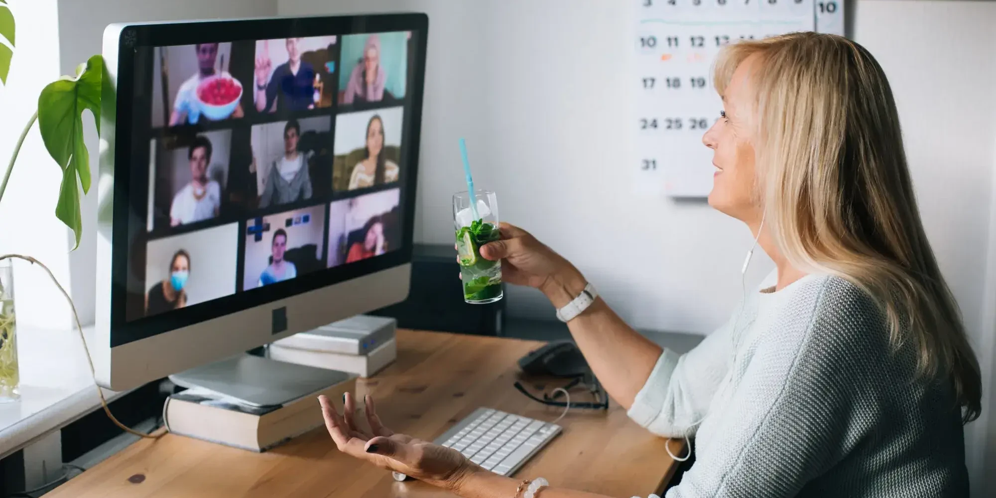 Woman holding mojito during cocktail making virtual team building event