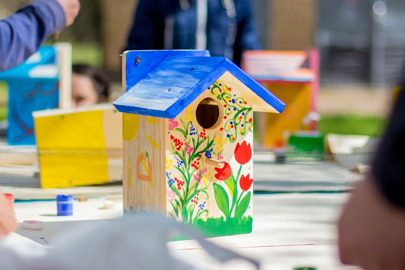 wooden birdhouse decorated with colourful flowers in team building activity