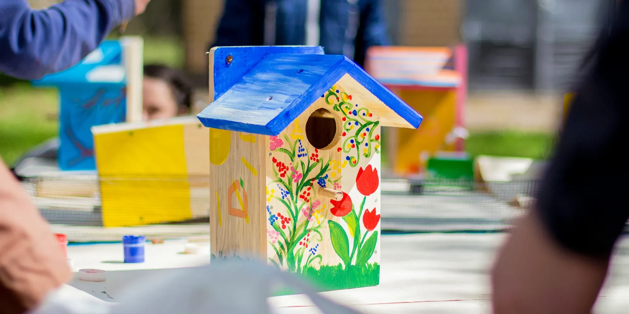 wooden birdhouse decorated with colourful flowers in team building activity